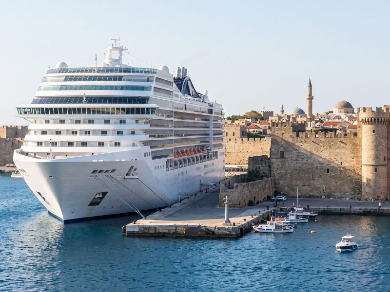 Large modern cruise ship berthed below the medieval walls of the Old Town of Rhodes
