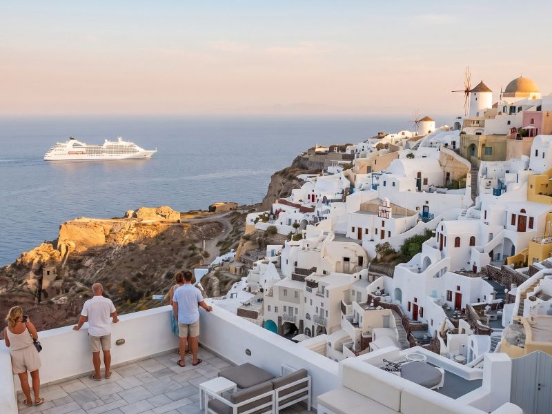 Oia op de noordpunt van Santorini in het late middaglicht, met een cruiseschip aan de horizon