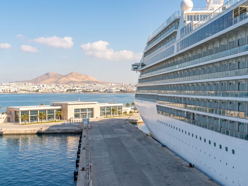 Large modern cruise ship at the La Goulette cruise terminal, with the Gulf of Tunis and the city behind
