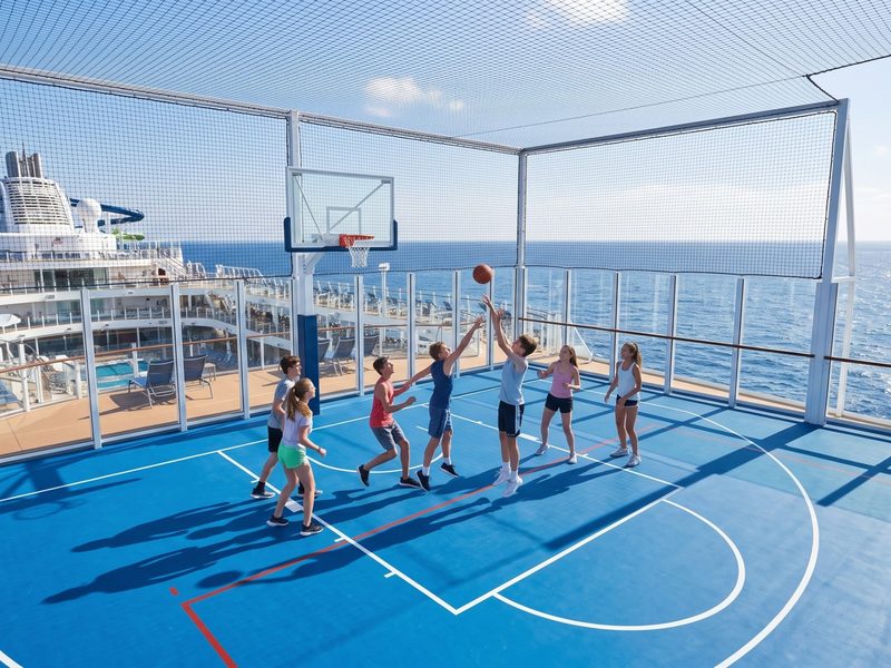 Adolescentes jogam basquete na quadra do deck superior de um navio de cruzeiro moderno